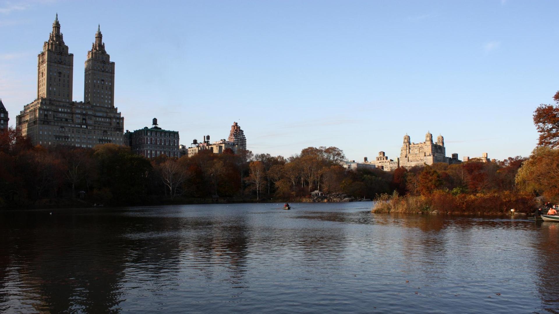 Ein Farbfoto zeigt den spätherbstlichen Central Park in New York mit den berühmten Apartmenthäusern "The San Remo" links) und "The Beresford"