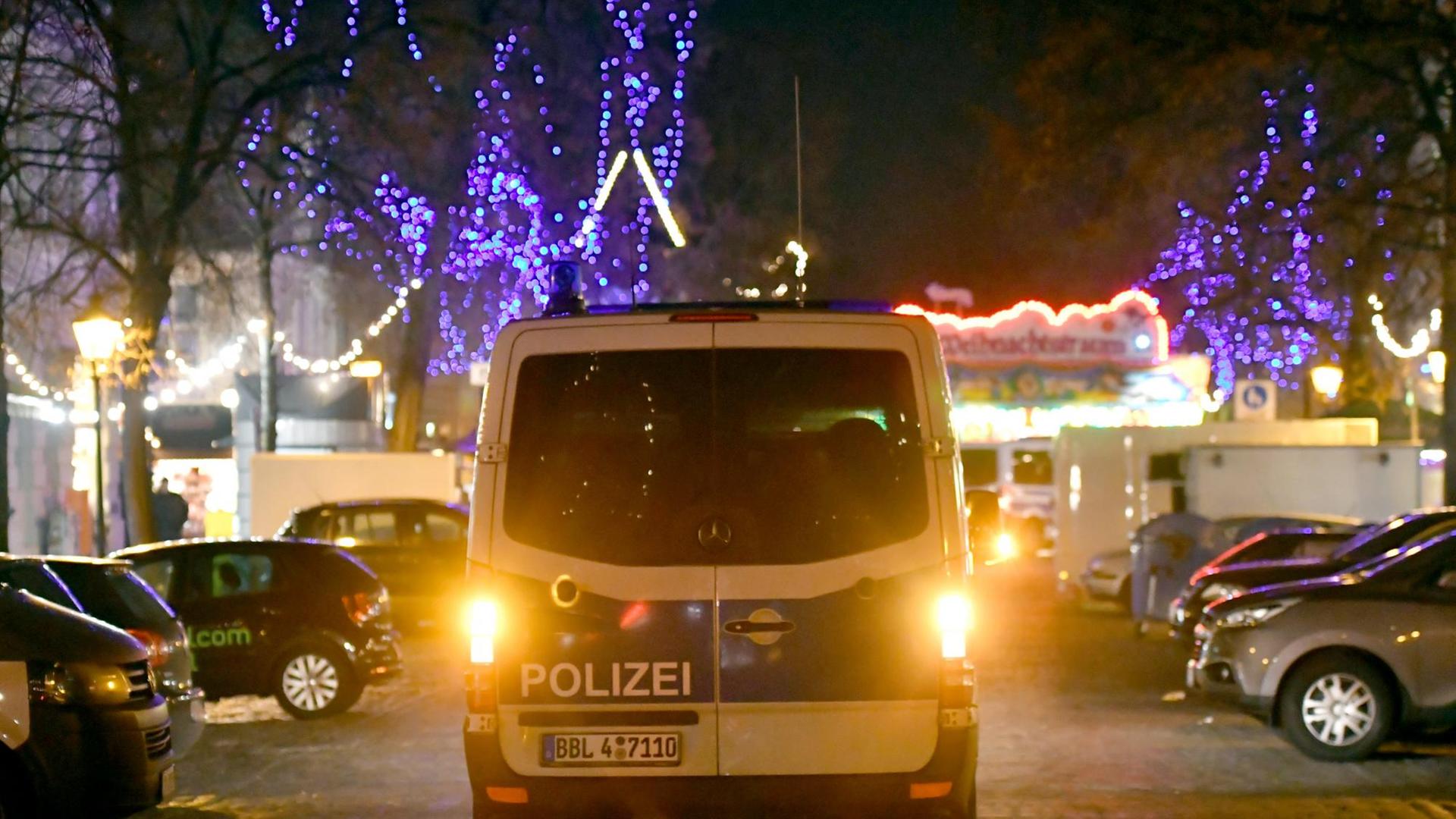 Ein Polizeifahrzeug fährt am 01.12.2017 auf einer Straße an einen Weihnachtsmarkt in der Innenstadt von Potsdam (Brandenburg). An dem Markt haben Bombenentschärfer am Freitag ein verdächtiges Paket unschädlich gemacht.