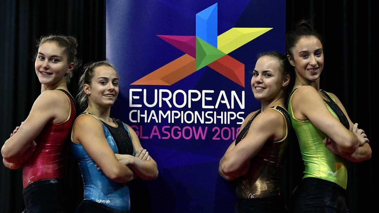 Die belgischen Turnerinnen Maellyse Brassart, Axelle Klinckaert, Senna Deriks und Nina Derwael stehen vor dem Logo der European Championships.