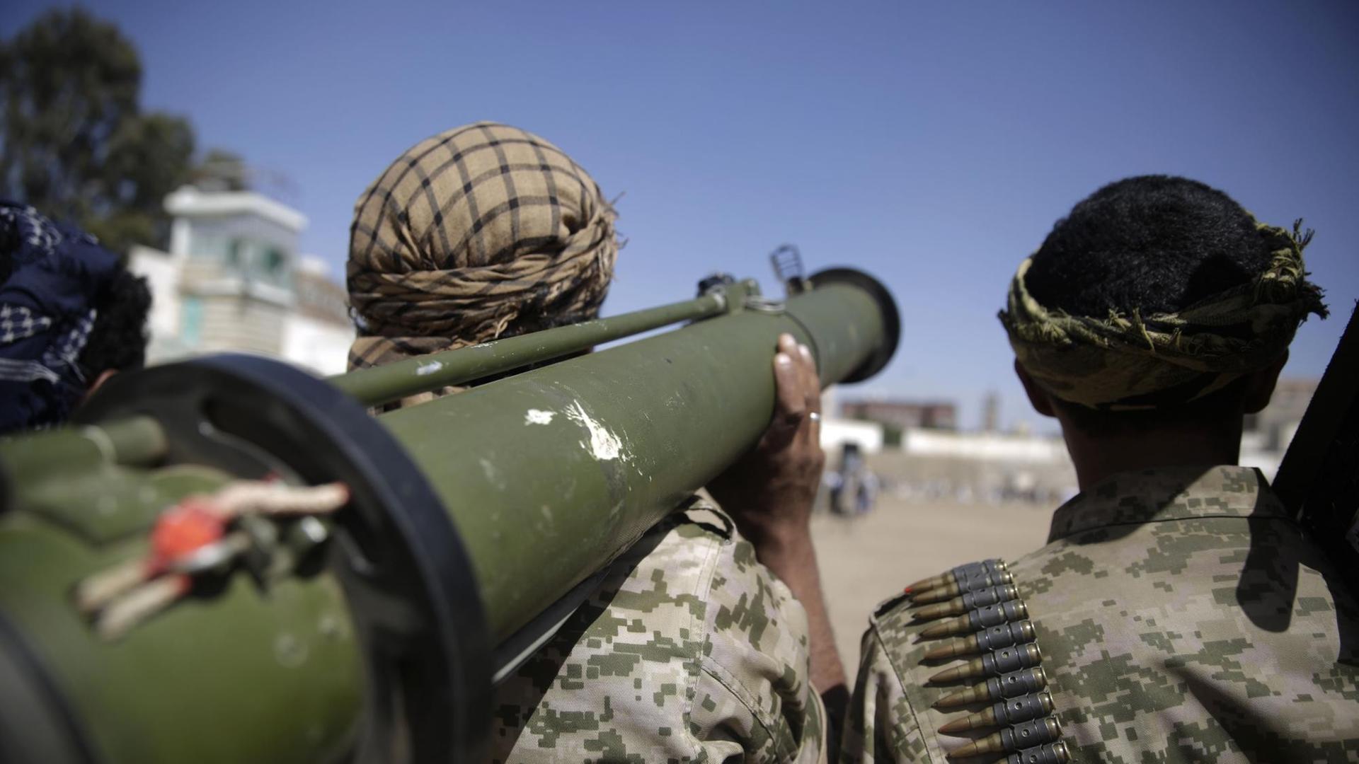 Rückansicht zweier Huthi-Kämpfer, einer trägt eine Panzerfaust auf der Schulter