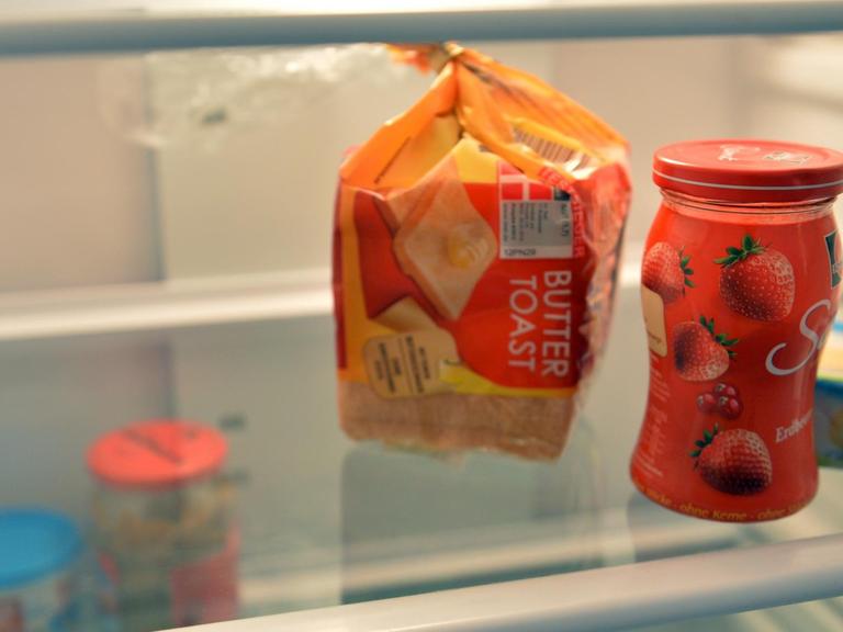 In einem fast leeren Kühlschrank stehen Toastbrot, Marmelade und Butter