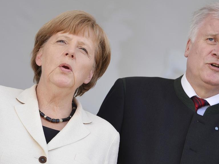 Bundeskanzlerin Angela Merkel (CDU) und Bayerns Ministerpräsident Horst Seehofer (CSU) singen am 21.05.2014 am Ende einer Kundgebung zur Europawahl vor der Marienkirche in Hof (Bayern) das Bayernlied.
