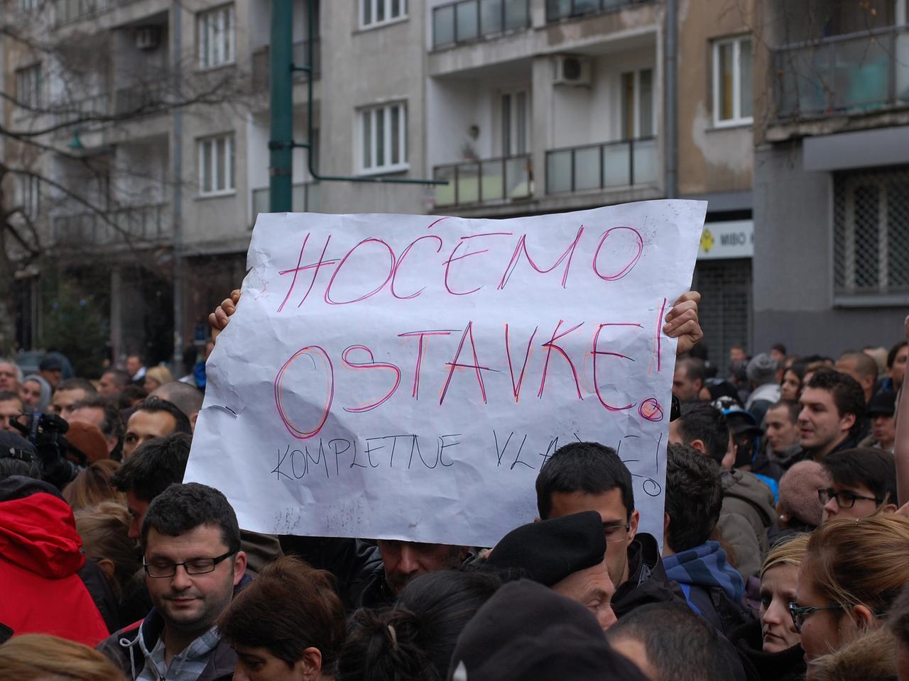 Demonstranten in Sarajevo: einer hält ein Plakat mit der Aufschrift: "Wir wollen den Rücktritt der gesamten Regierung!"