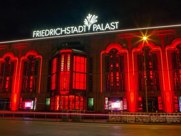 Der abendliche Friedrichstadt-Palast in Berlin, rot angestrahlt.