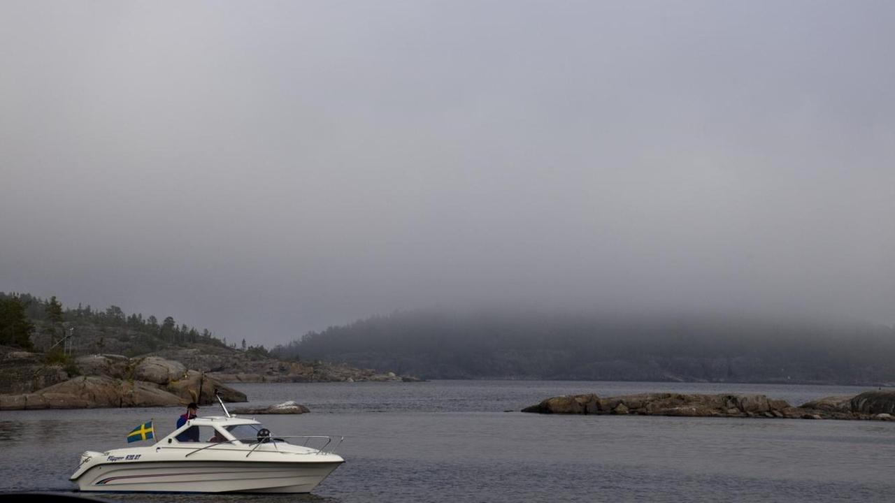 Ein Motorboot durchfährt bei aufkommendem Nebel die Schäreninseln vor der schwedischen Ostküste.