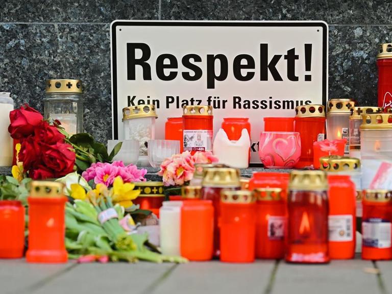 In der Nähe des Tatortes am Heumarkt in Hanau wurden Kerzen, Blumen und ein Schild mit der Aufschrift "Respekt! Kein Platz für Rassismus" niedergelegt.