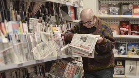 Ein Zeitung lesender Mann in einem Zeitungskiosk in Krakau.