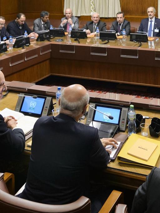 Die Teilnehmer der Syrien-Friedensgespräche sitzen an einem viereckigen Tisch in einem Gebäude der Vereinten Nationen in Genf zusammen. at the opening of Syrian peace talks with the Syrian government delegation at the United Nations (UN) Offices in Geneva
