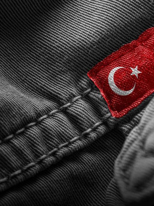 Eine türkische Flagge ist als Label auf ein dunkles Kleidungsstück genäht.