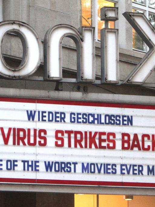 "Wieder geschlossen - Das Virus schlägt zurück Teil 2 - Einer der schlechtesten Filme, die je gedreht wurden" steht auf Englisch über dem Eingang eines Kinos.