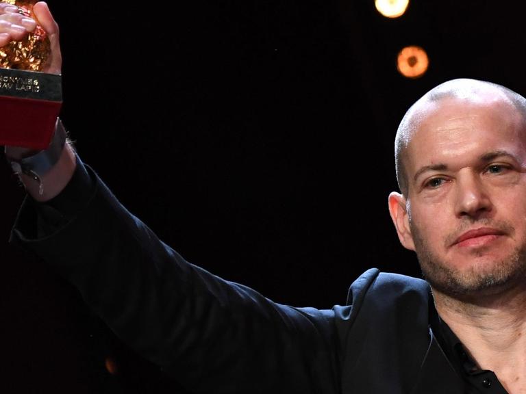 Nadav Lapid, Regisseur des Films "Synonymes" hält den ihm verliehenen Goldenen Bären nach oben.