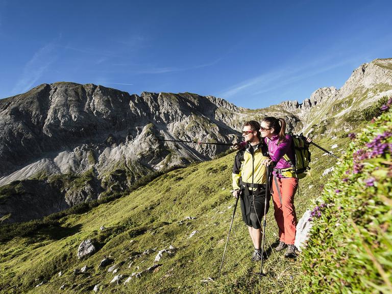 Ein junges Paar wandert in den Alpen bei Altenmarkt-Zauchensee in Österreich.