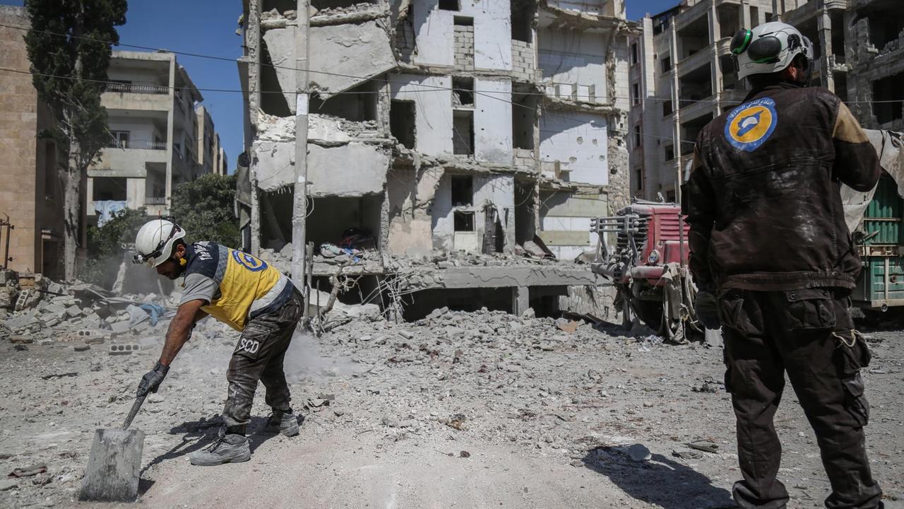 "Weißhelme" räumen Schutt vor einem von einem Luftangriff zerstörten Gebäude in Idlib (Syrien).