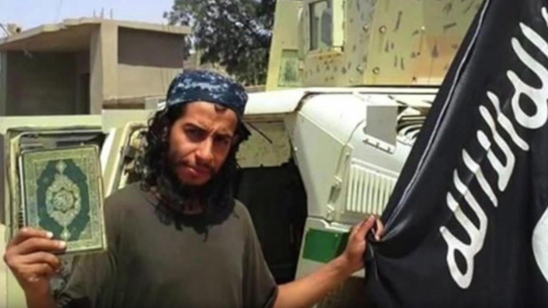 Abdelhamid Abaaoud hält einen Koran und eine IS-Flagge in die Kamera.