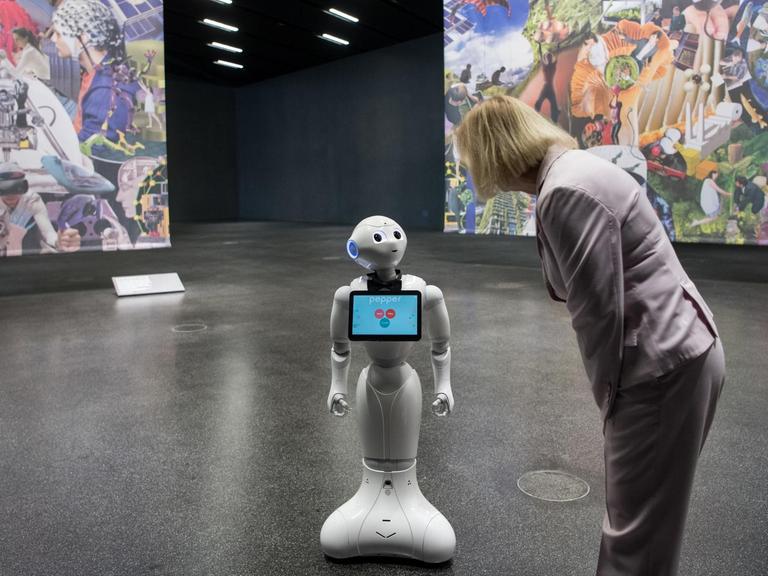 Bildungsministerin Johanna Wanka (CDU) nimmt Kontakt mit Roboter Pepper auf. Die Interaktion zwischen Mensch und Roboter ist eines der Themen der Berliner "Science Week".