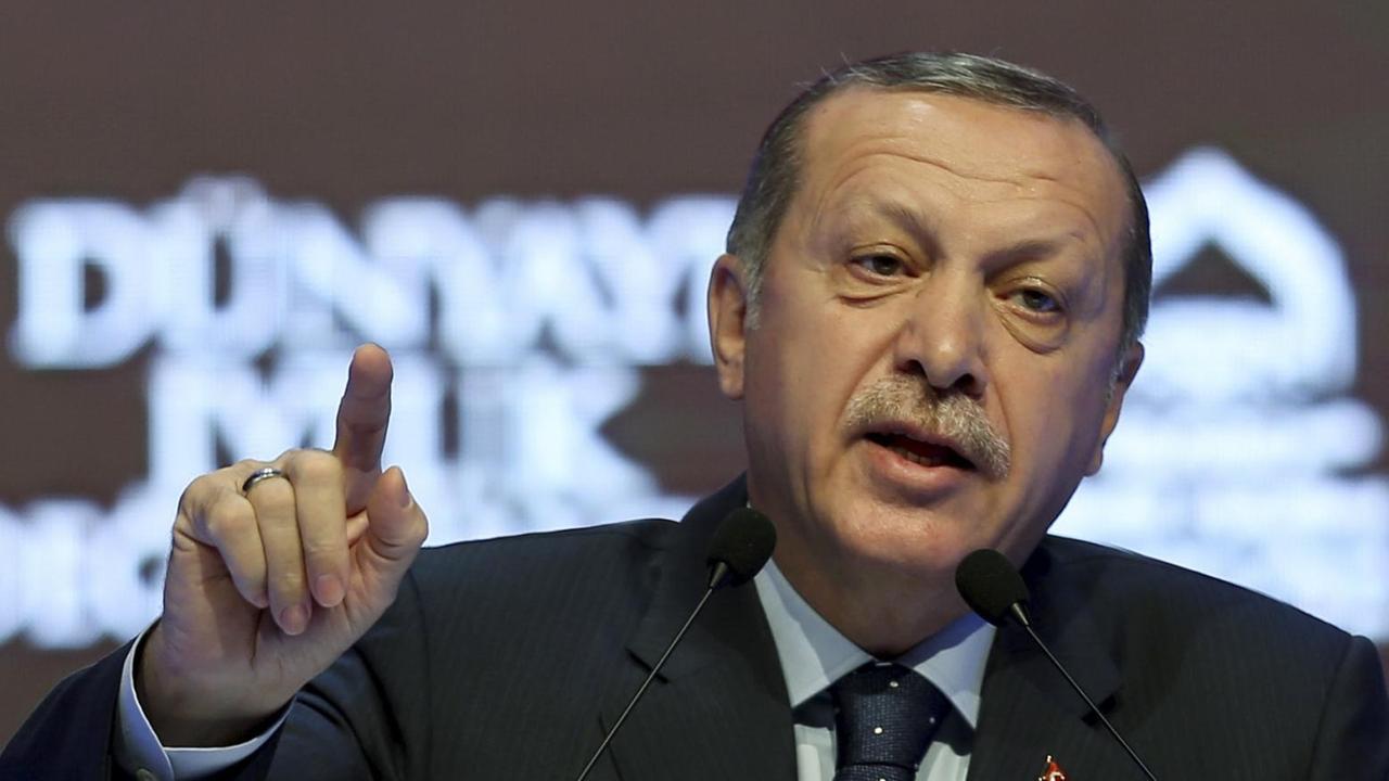 Erdoğan spricht mit erhobenem Zeigefinger an einem Rednerpult.