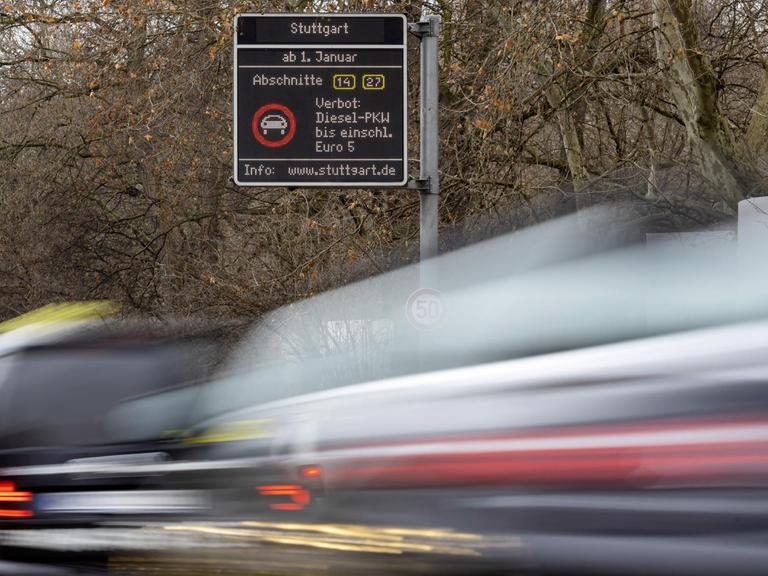 Autos fahren schnell vorbei, ein Wischeffekt entsteht. Ein Schild über der Cannstatter Straße in Stuttgart weist auf kommende Fahrverbote hin.