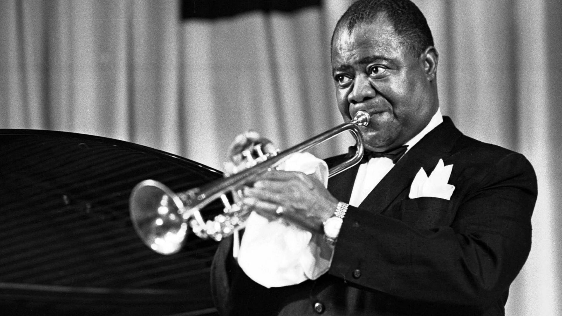 Der amerikanische Jazz-Trompeter und Sänger Louis "Satchmo" Armstrong spielt Trompete.