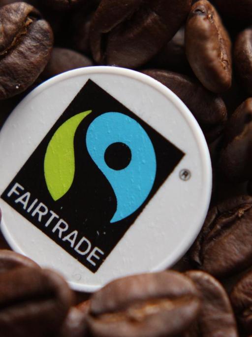 Fairtrade Siegel zwischen Kaffeebohnen