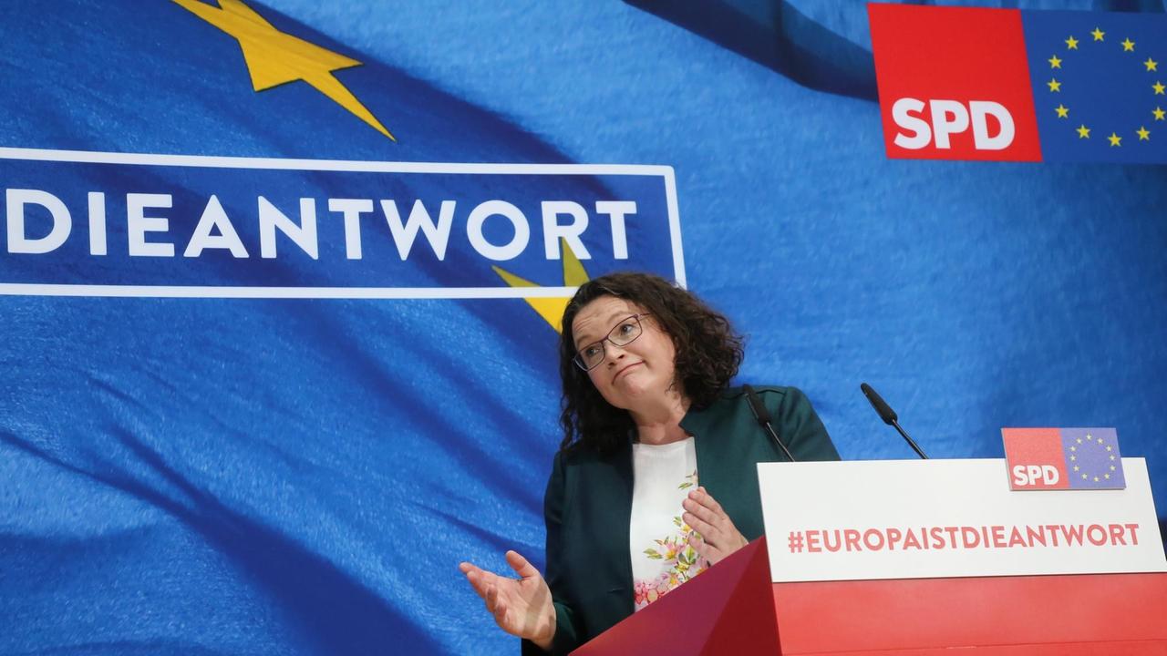 Das Bild zeigt Andrea Nahles. Sie schaut ratlos in die Menge und zuckt dabei mit den Schultern. Im Hintergrund ist das SPD-Wahlmotto "Die Antwort" zu lesen.