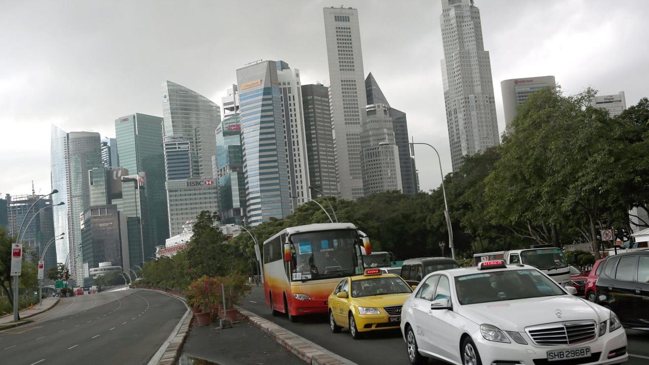 Autos fahren über eine mehrspurigen Straße in Singapur.