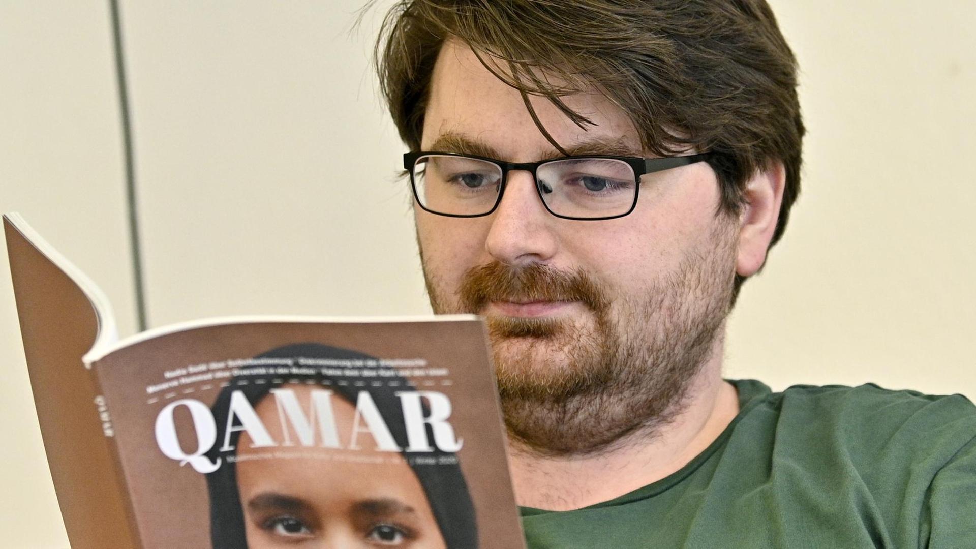 Muhamed Beganovic, Gründer des muslimischen Magazins "Qamar" blättert durch eine Ausgabe seines Magazins.