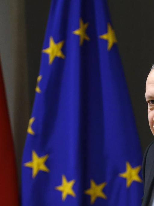 Der türkische Präsident Recep Tayyip Erdogan vor einer türkischen und einer europäischen Flagge.