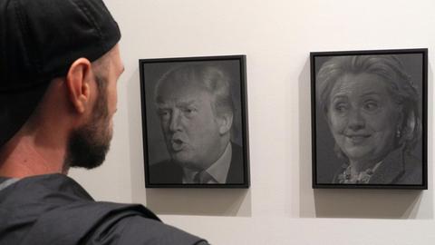 Besucher betrachten am 13.10.2016 die Porträts "Trump (Clinton)" (l) und "Clinton (Trump)" (r) des Künstlers Alfred Steiner in der Ausstellung «Why I Want to Fuck Donald Trump» in der Joshua Liner Gallery in New York (USA).