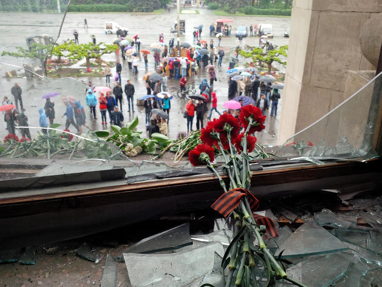 Rote Nelken liegen einem zerstörten Fenster des Gewerkschaftshaus in Odessa
