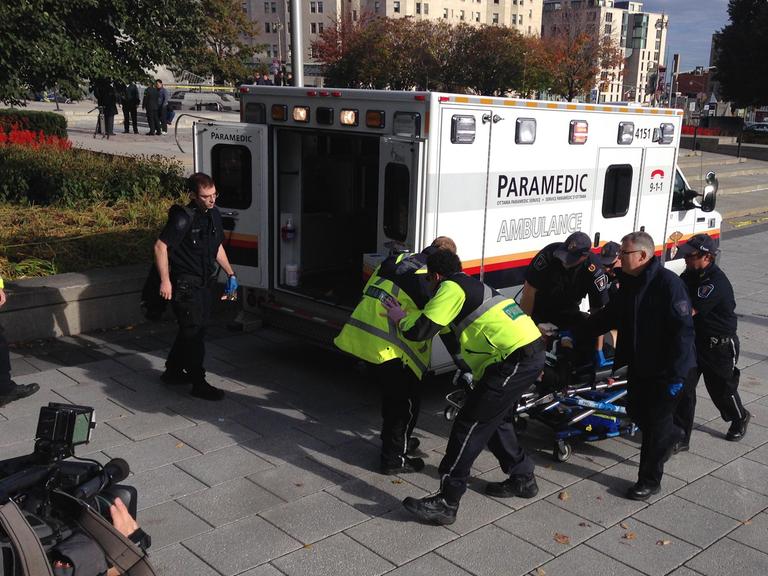 Polizei und Sanitäter beim Abtransport des verletzten Wachsoldaten vor dem Parlament in Ottawa.