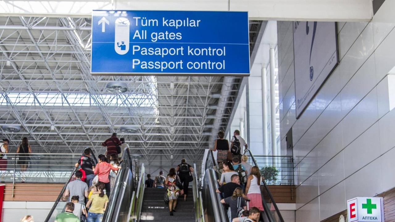 Flughafen Antalya: Menschen stehen auf einer Rolltreppe zur Passkontrolle