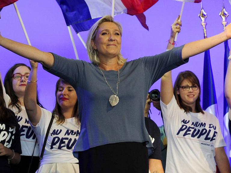 Marine Le Pen, Vorsitzende des rechtsextremen Front National, steht bei einem Kongress der Partei im südfranzösischen Frejus mit ausgebreiteten Armen auf der Bühne.