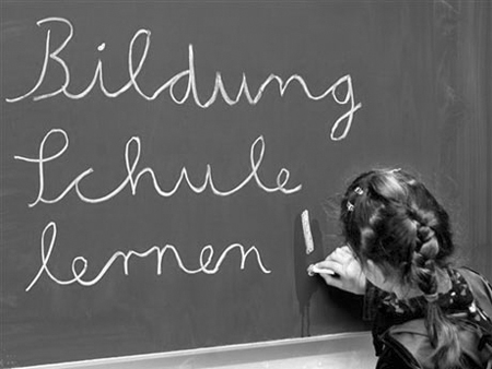 Eine Schülerin einer dritten Grundschulklasse in Frankfurt am Main schreibt an einer Tafel.