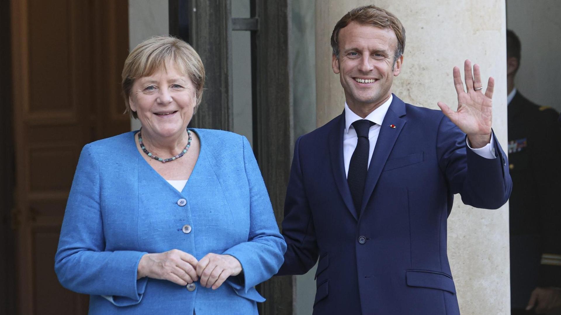 Frankreichs Präsident Emmanuel Macron begrüßt Bundeskanzlerin Angela Merkel vor dem Elysee Palast.