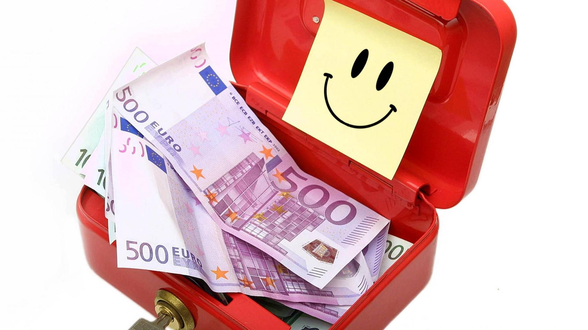 Eine Geldschatulle mit 500-Euro-Scheinen und einem Smily.
