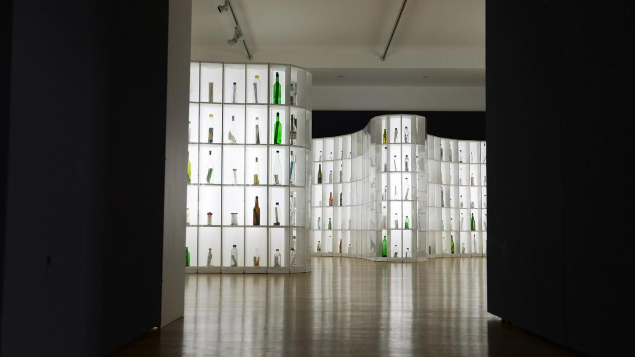 Flaschen stehen in Regalen in der Bingener Ausstellung "1001 Flaschenpost".