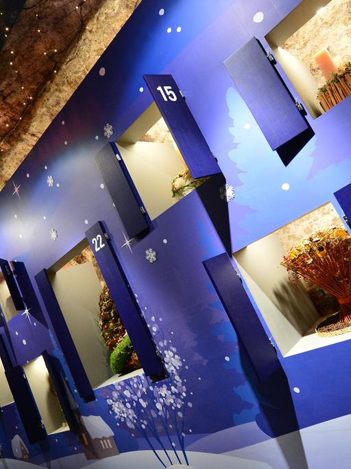 In der Ausstellung "Florales zur Weihnachtszeit" in Erfurt betrachtet eine Besucherin die Exponate. Im Felsenkeller am Domplatz präsentieren der egapark Erfurt und Floristen weihnachtliche Blumenbindekunst.