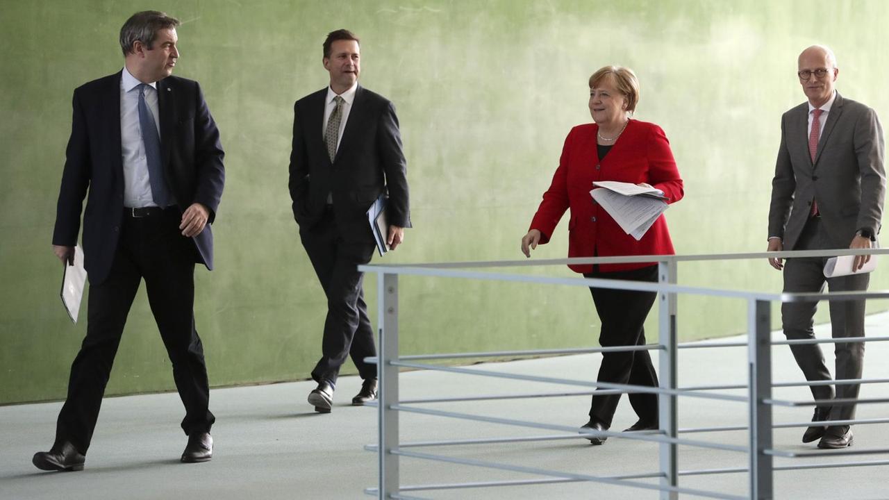 Bundeskanzlerin Angela Merkel (CDU, 2.v.r.) Markus Söder (CSU, l.), Ministerpräsident von Bayern, Peter Tschentscher (SPD, r.), Erster Bürgermeister von Hamburg und Regierungssprecher Steffen Seibert (2.v.l.) vor einer gemeinsamen Pressekonferenz. 