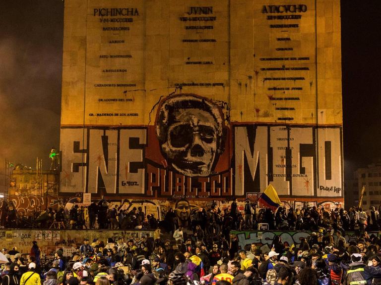 In der kolumbianischen Stadt Bogoto Cundinamarca wurde zum Protest ein Denkmal bemalt. Es zeigt das Gesicht des Ex-Präsidenten Alvaro Uribe, das sich in einen Totenschädel verwandelt und daneben steht "Volksfeind" geschrieben.
