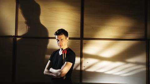 Der Perkussionist Alexej Gerassimez mit Schlägeln in der Hand, im Hintergrund sein Schatten auf einer Wand