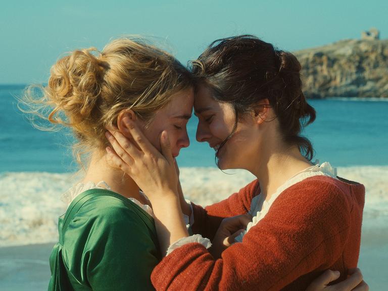 Zwei Frauen umarmen sich am Strand (Szene aus "Porträt einer jungen Frau in Flammen")