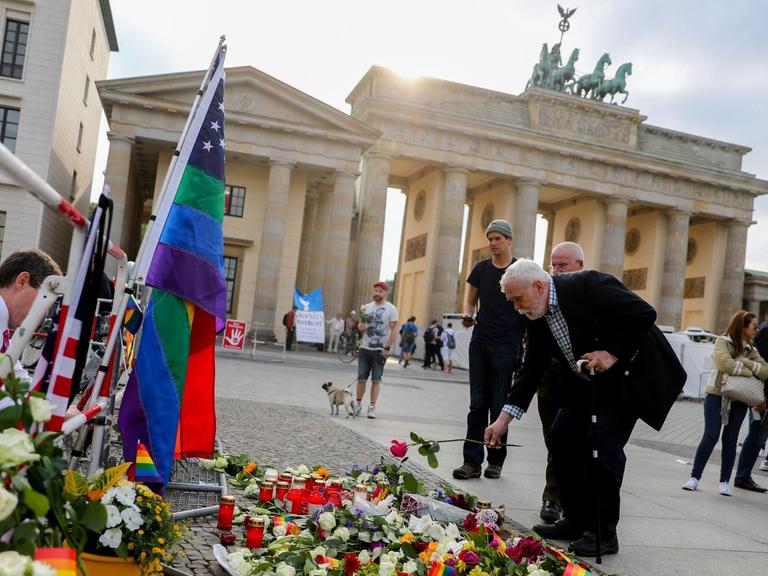 Passanten legen am 13.06.2016 in Berlin vor der Botschaft der USA am Brandenburger Tor im Gedenken der Opfer des Attentats in Orlando Blumen nieder.