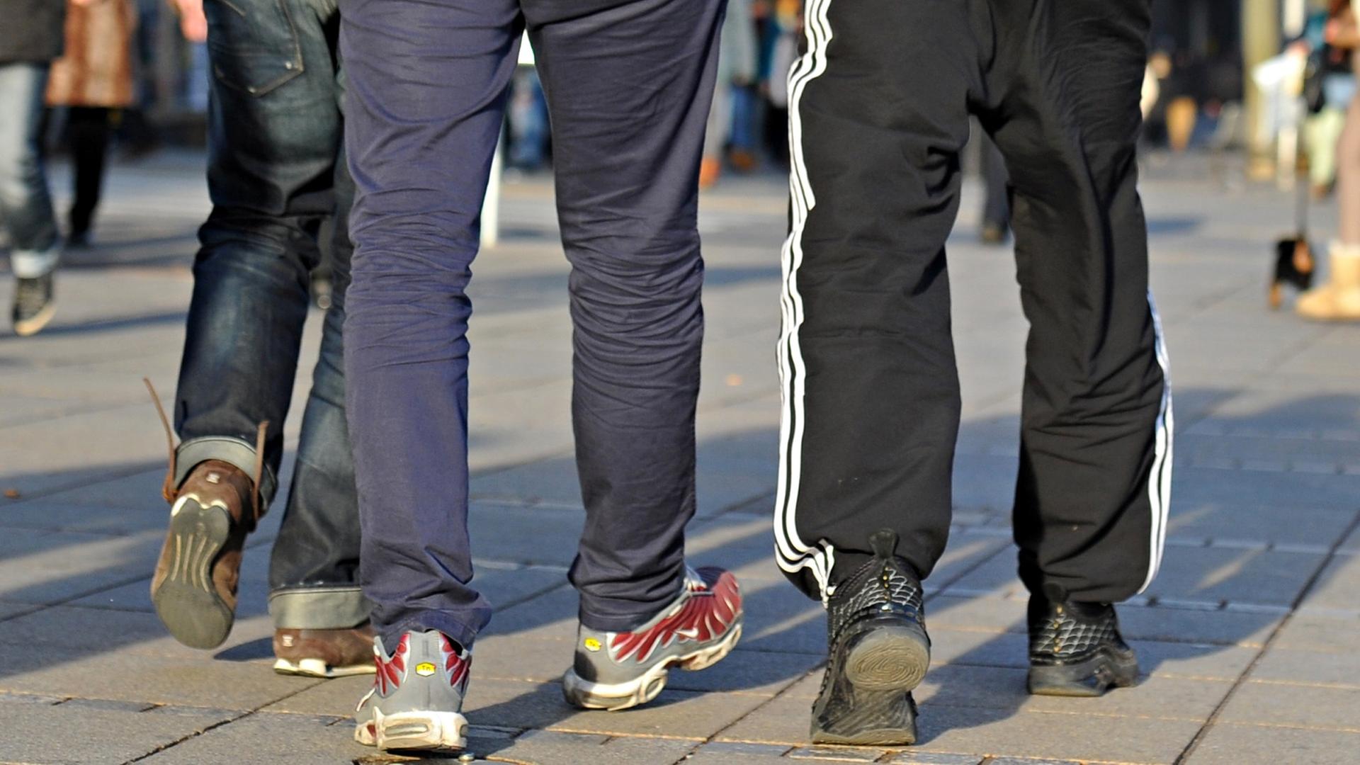 Das Bild zeigt die Beine der drei, nur einer von ihnen trägt eine Jogginghose.