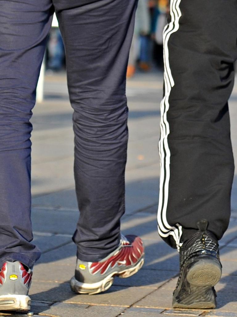 Das Bild zeigt die Beine der drei, nur einer von ihnen trägt eine Jogginghose.