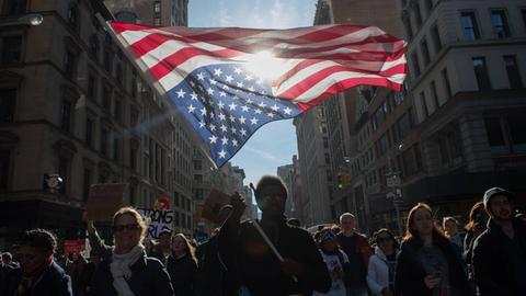 Ein Demonstrant hält eine auf dem Kopf stehende US-Flagge während einer Demonstration