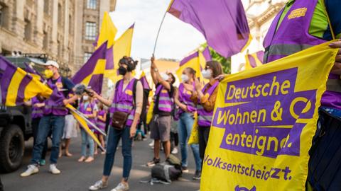 Unterstützer der Initiative "Deutsche Wohnen & Co. enteignen" schwenken bei der Übergabe der gesammelten Unterschriften für einen Volksentscheid zur Enteignung von großen Immobilienunternehmen vor der Senatsverwaltung für Inneres und Sport Fahnen.