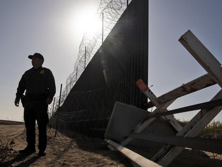 Der Grenzschutzbeamte Anthony Garcia steht im Gegenlicht entlang der US-amerikanischen Grenze zu Mexiko.
