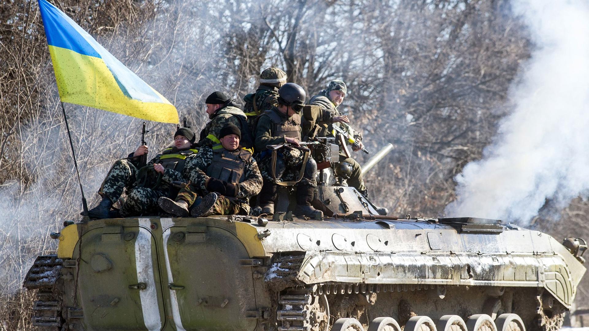 Ein Panzer mit ukrainischer Fahne und Soldaten zieht sich aus Debalzewe zurück.