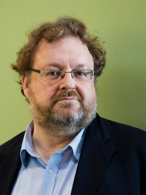 Der FAZ-Redakteur Jürgen Kaube, Man mit Brille und vor grüner Wand, in die Kamera blickend.