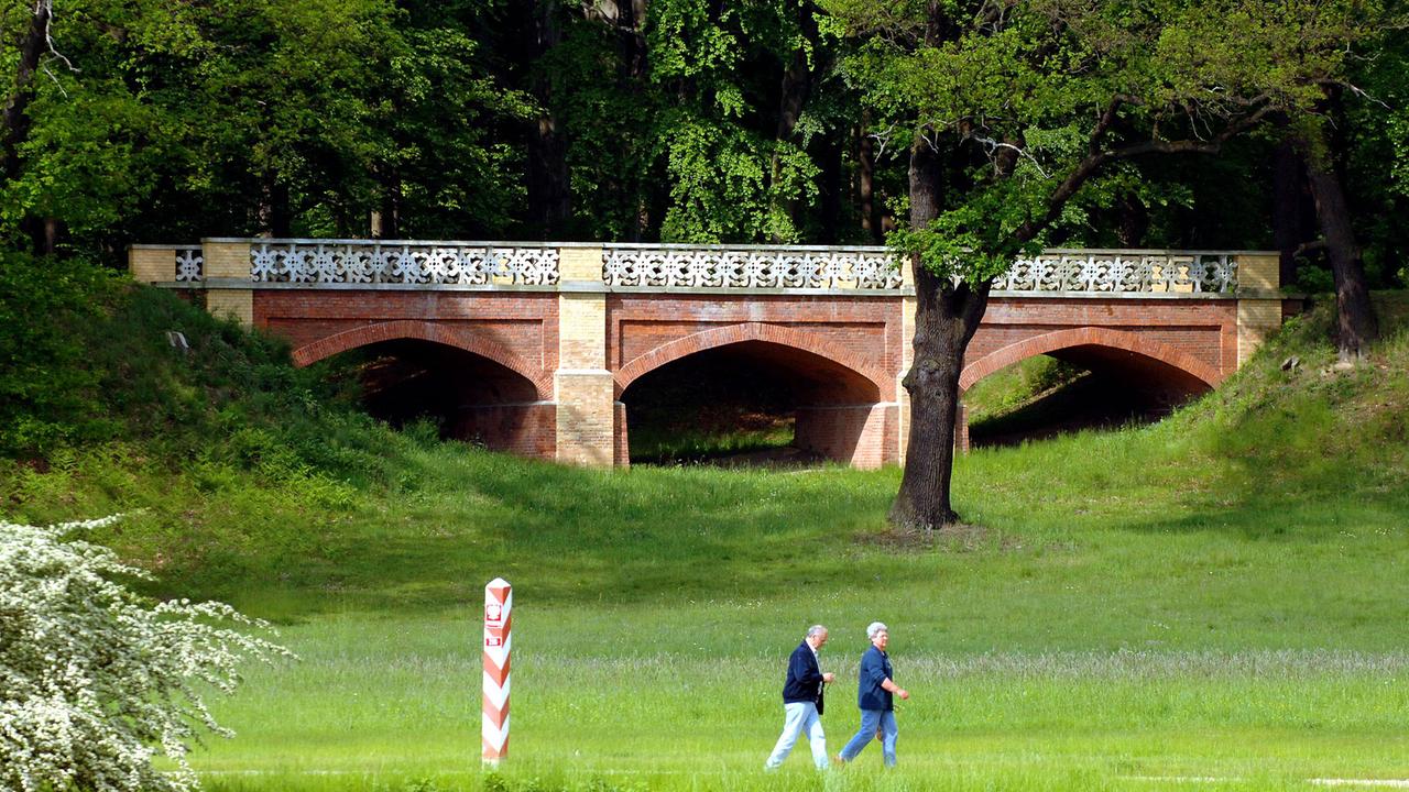 Besucher wandern im Fürst-Pückler-Park in Bad Muskau.